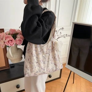 Floral canvas shoulder bag featuring delicate lace edges and a decorative bow charm