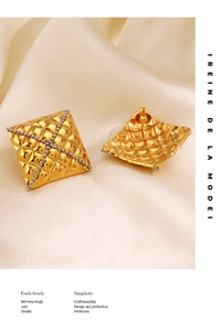 Detail view of gold quilted square stud earrings with silver crisscross bead pattern