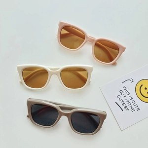 Detailed top view of three chic girls' sunglasses in pink, cream, and grey resin frames