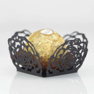 Detail of laser-cut black hollow rose lace wrapper for wedding party chocolate decoration