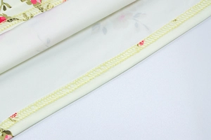 Detail of pink floral print on white fabric with professional yellow hem stitching