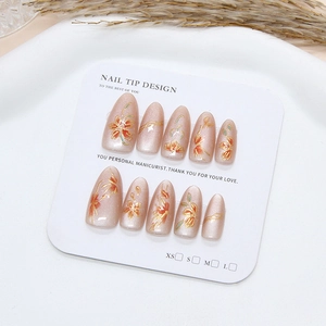 Handmade champagne cat eye press-on nails with red floral art and golden lines in almond shape