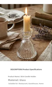 Detail of vintage skirt-shaped glass candle holder with glowing pillar candle