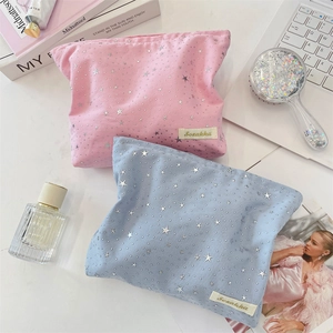 Detailed view of pastel pink and blue star patterned makeup bags in a home setting