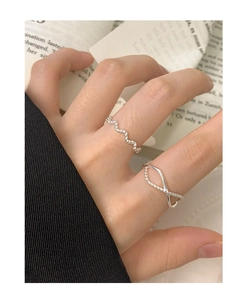 Close-up of S925 sterling silver wave ring and twisted rope stackable rings on finger