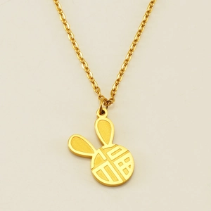 Detail of 18k gold rabbit pendant with lucky Fu character carving and cross chain link