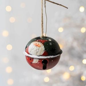 Gros plan de cloches de Noël rétro en fer avec peinture Père Noël sur une branche