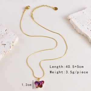 Detail shot of purple glass butterfly pendant on a gold stainless steel chain necklace