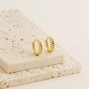 Macro view of gold S925 sterling silver hoop earrings with croissant textured design