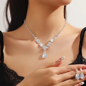 Close-up of sparkling silver bridal jewelry set with pear-cut crystals on a model