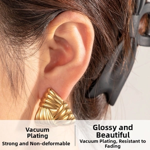 Macro shot of gold-plated heart earring showing detailed texture and metallic luster