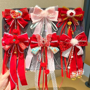 Detailed view of red velvet New Year hair clips with tassels and traditional embroidery