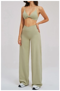Detail of sage green yoga set with crossover high waist and flared leg fitness pants