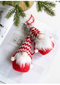 Pair of plush Christmas gnomes with knit hats and faux fur beards on a vintage book