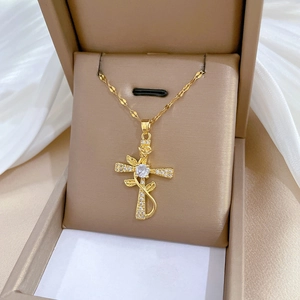 Golden titanium cross necklace with rose vine and cubic zirconia in a jewelry box