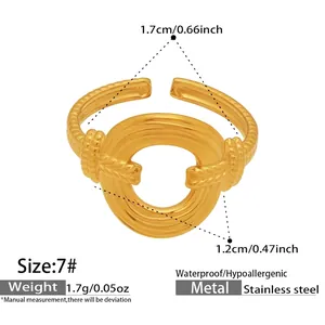 Detail of waterproof gold stainless steel twisted open ring with circular hollow design