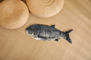 Realistic fish plush cushion shell on light wood floor with a warm home atmosphere