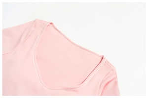 Dettaglio della maglia da yoga rosa a maniche lunghe con scollo a U e doppie cuciture rifinite