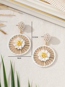 Macro detail of Bohemian raffia flower earrings with pearls and dimensions of 6.2cm x 4cm