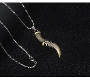 Close-up of a punk grim reaper scythe pendant with textured bronze finish and box chain