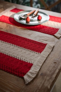 Close-up of red and white woven cotton Christmas placemat with decorative fringe detail
