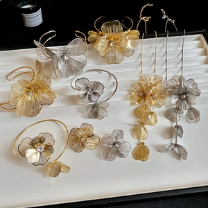 Detail of hollow flower jewelry set with rhinestones and tassel earrings on a tray