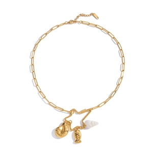 Macro shot of gold star pendant with seashell charms on a paperclip chain necklace