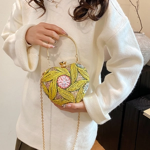 Sparkly heart-shaped sequin evening bag with green floral beadwork and gold handle