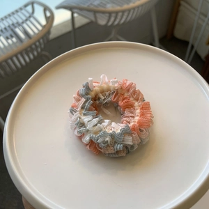 Détail de chouchous à rayures volantées orange et bleu sur une assiette en céramique