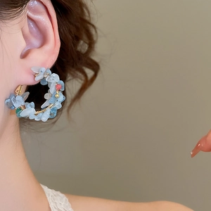 Close-up of blue natural stone and pearl hoop earring on model showing detail