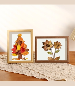 Detail of DIY dried leaf collage in wood frames on a beige lace runner centerpiece