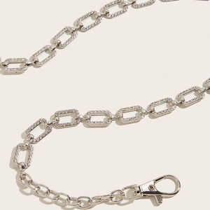 Close-up of silver chain belt with rhinestone-encrusted rectangular links and lobster clasp