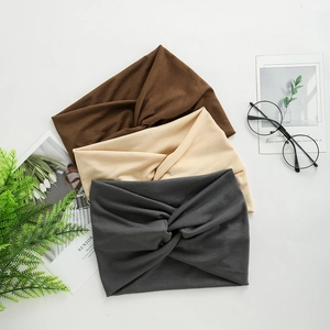 Close-up of wide knotted yoga headbands in gray, beige and brown soft jersey fabric