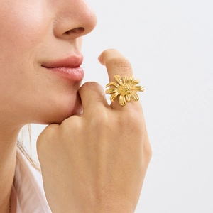 Detail of sunflower shape ring in golden finish featuring delicate petal textures