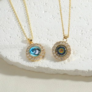 Detailed close-up of golden necklaces featuring evil eye pendants with zircon accents