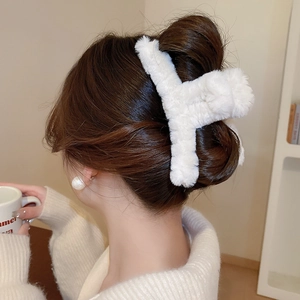 Close-up of white plush hair claw clip used in elegant French twist hairstyle