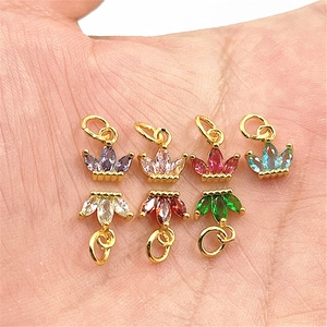 Macro shot of colorful zircon crown charms on a palm showing the miniature size