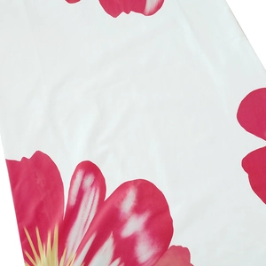 Close-up of vibrant pink floral print on soft white summer dress fabric texture