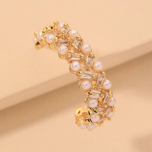 Detail of C-shaped gold-plated ear cuff featuring inlaid pearls and rectangular zircons