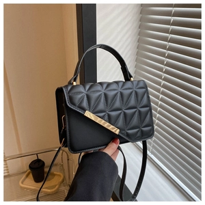 Dettaglio della borsa in ecopelle nera trapuntata con raffinati inserti in metallo oro