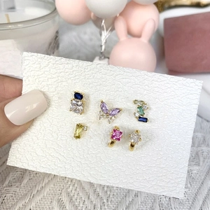 Detailed view of handmade earrings with colorful zircon stones and sequins on card