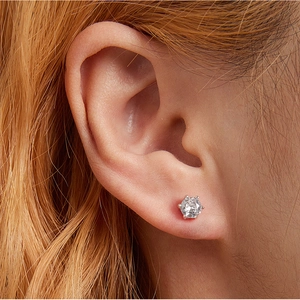 Detail showing a 925 sterling silver six-prong cubic zirconia stud earring on an ear