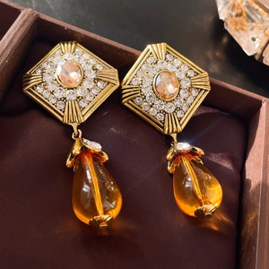 Détail de boucles d'oreilles vintage en or avec diamants et perles ambre en boîte