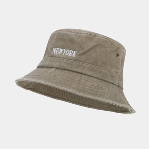 Detailed macro view of white NEWYORK embroidery on vintage wash cotton bucket hat