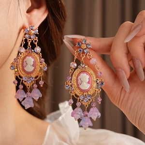 Vintage court style earrings featuring pink cameo portraits and purple floral tassels