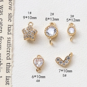 Detailed view of gold-plated heart and star pendants with inlaid cubic zirconia crystals