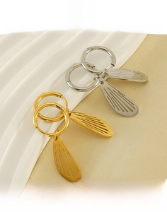 Detailed view of hollow wing earrings in gold and silver finish made of titanium steel