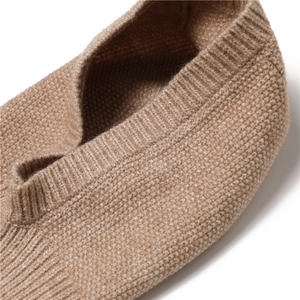Detailed close-up of beige ribbed knit texture and soft fabric on the winter hood scarf
