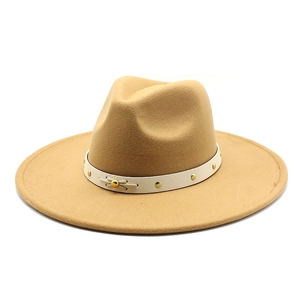 Detail of camel wool fedora hat featuring a white faux leather band with gold rivets