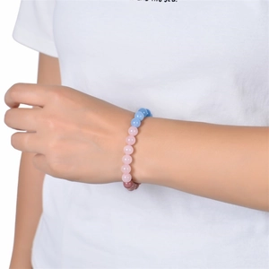 Macro detail of elastic fertility bracelet with pink, blue, and purple gemstone beads